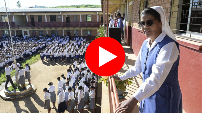 Die Ordensfrau Schwester Rolandine steht auf einem Balkon einer Schule in Madagaskar. Unter ihr im Hof haben sich Hunderte Schüler zum Morgengebet. aufgestellt.
