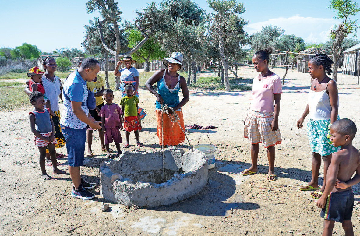 Eine Gruppe Madagassen steht um einen Brunnen.